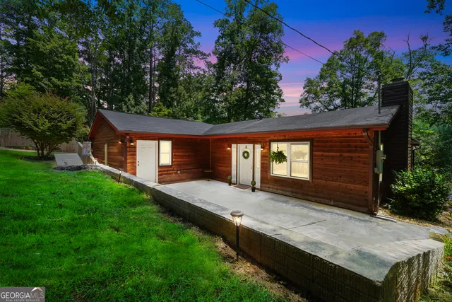 a front view of house with yard and trees in the background