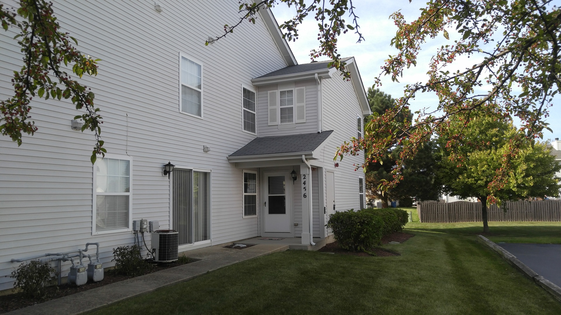 a front view of a house with a garden and trees