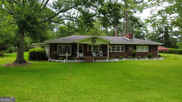 a patio with a table and chairs under an umbrella