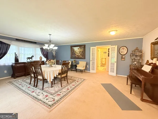 a dining room with wooden floor a chandelier a wooden table and chairs