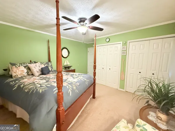 a bed sitting in a bedroom next to a window and a chandelier