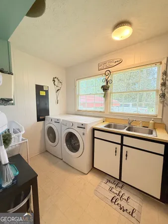 a utility room with sink dryer and washer