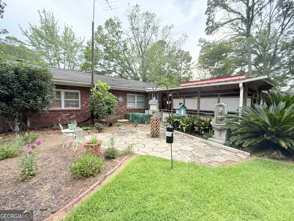 a view of house with a yard and table under an umbrella