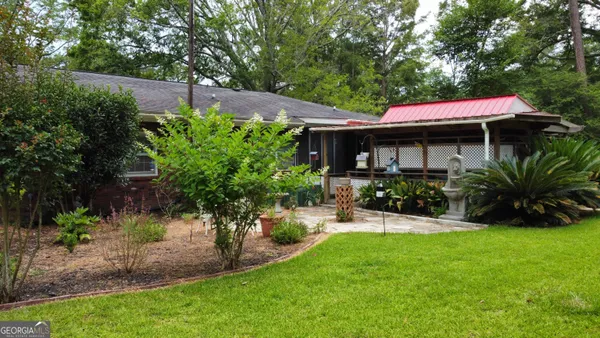 a view of a house with a yard and sitting area
