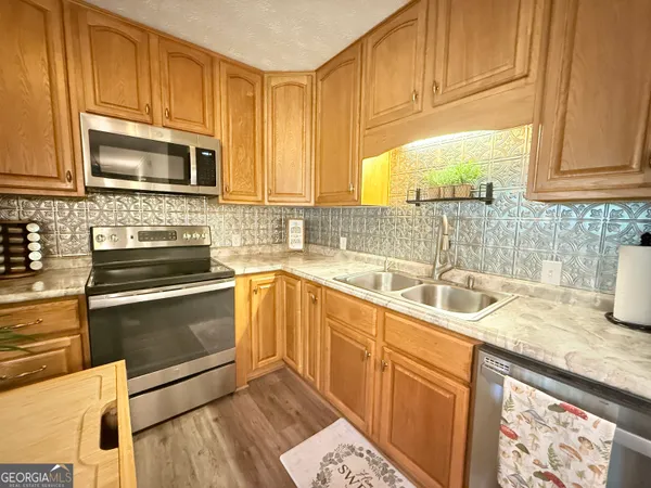 a kitchen with stainless steel appliances granite countertop a sink stove and microwave