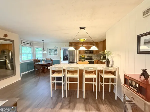 a dining room with furniture a chandelier and wooden floor