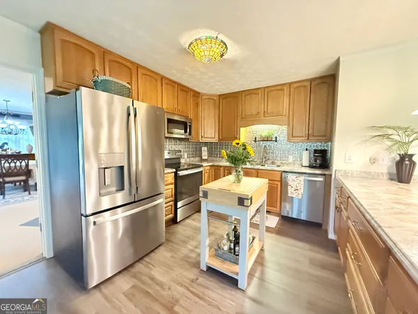 a kitchen with granite countertop a refrigerator stove top oven and sink