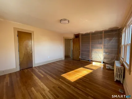 a view of empty room with wooden floor