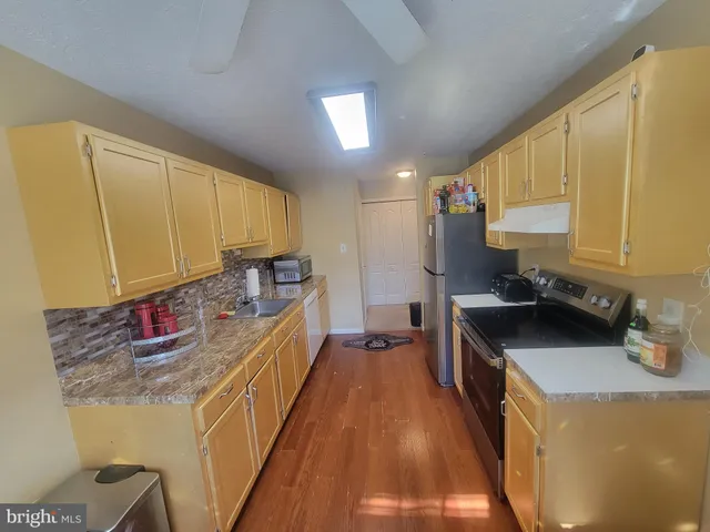 a kitchen with granite countertop a sink a stove and cabinets