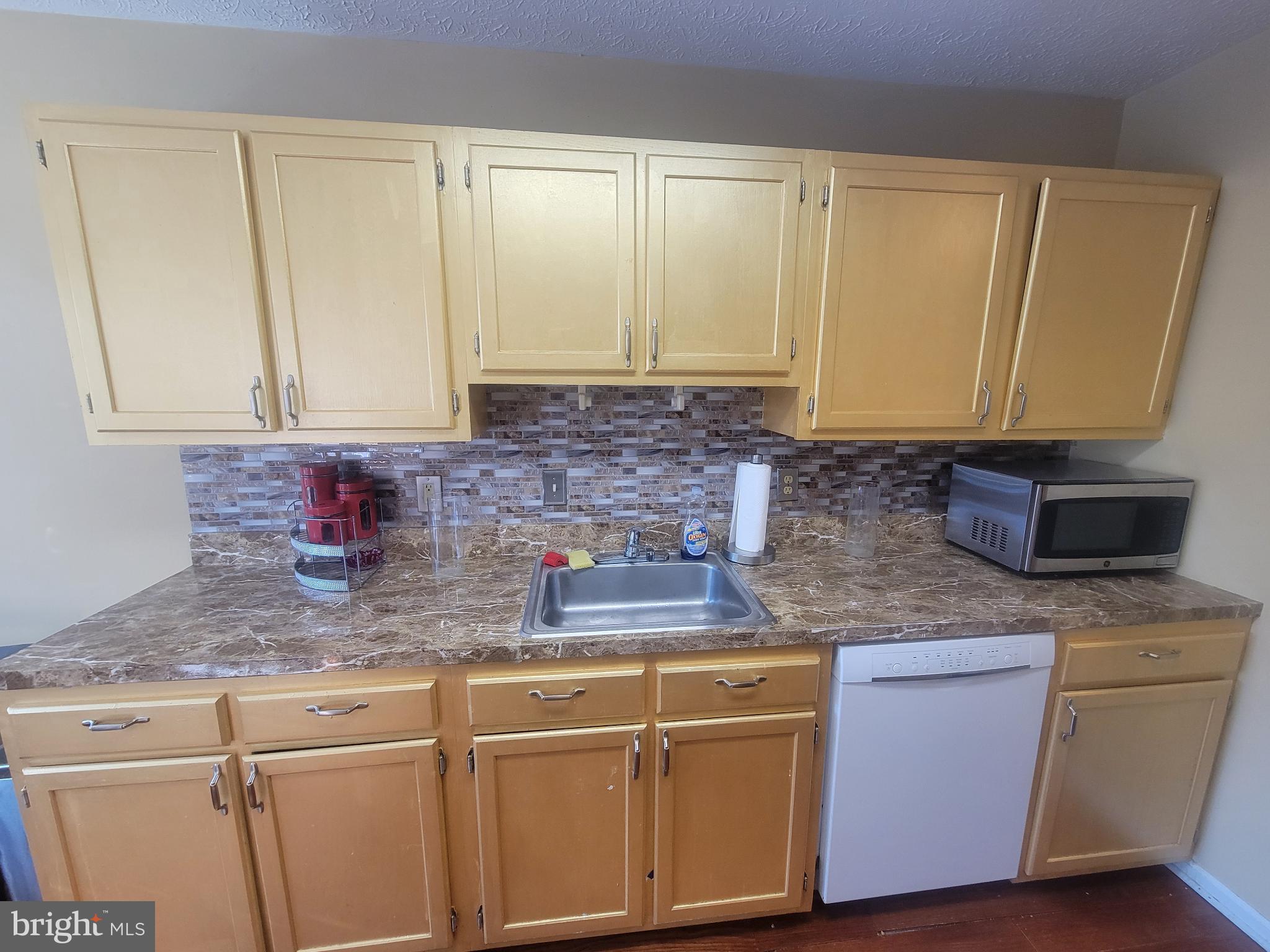 4634 Deepwood Court, Unit 89E Bowie, MD 20720 - Photo 16 of 29 a kitchen with granite countertop a sink a stove and cabinets