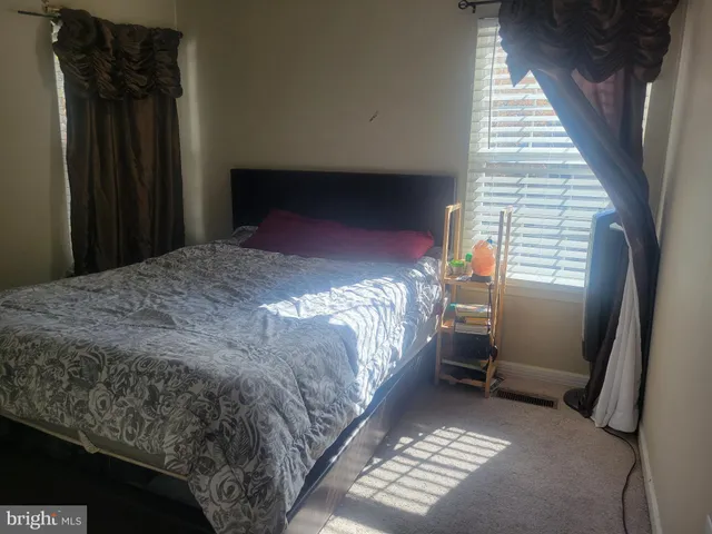 a bed sitting in a bedroom next to a window