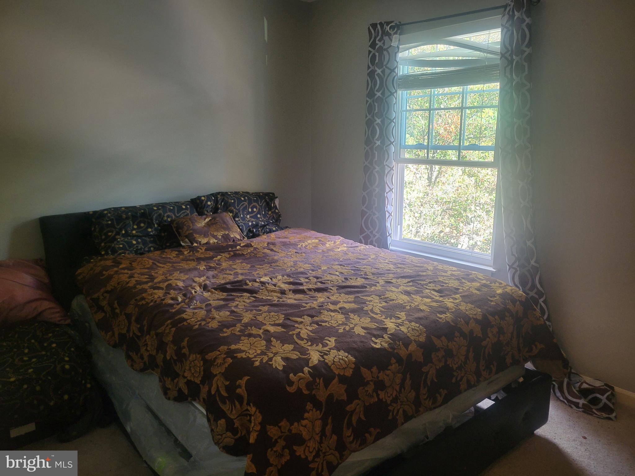 4634 Deepwood Court, Unit 89E Bowie, MD 20720 - Photo 19 of 29 a bed sitting in a bedroom next to a window