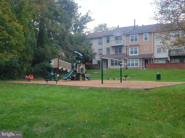 a view of a big house with a big yard and large trees