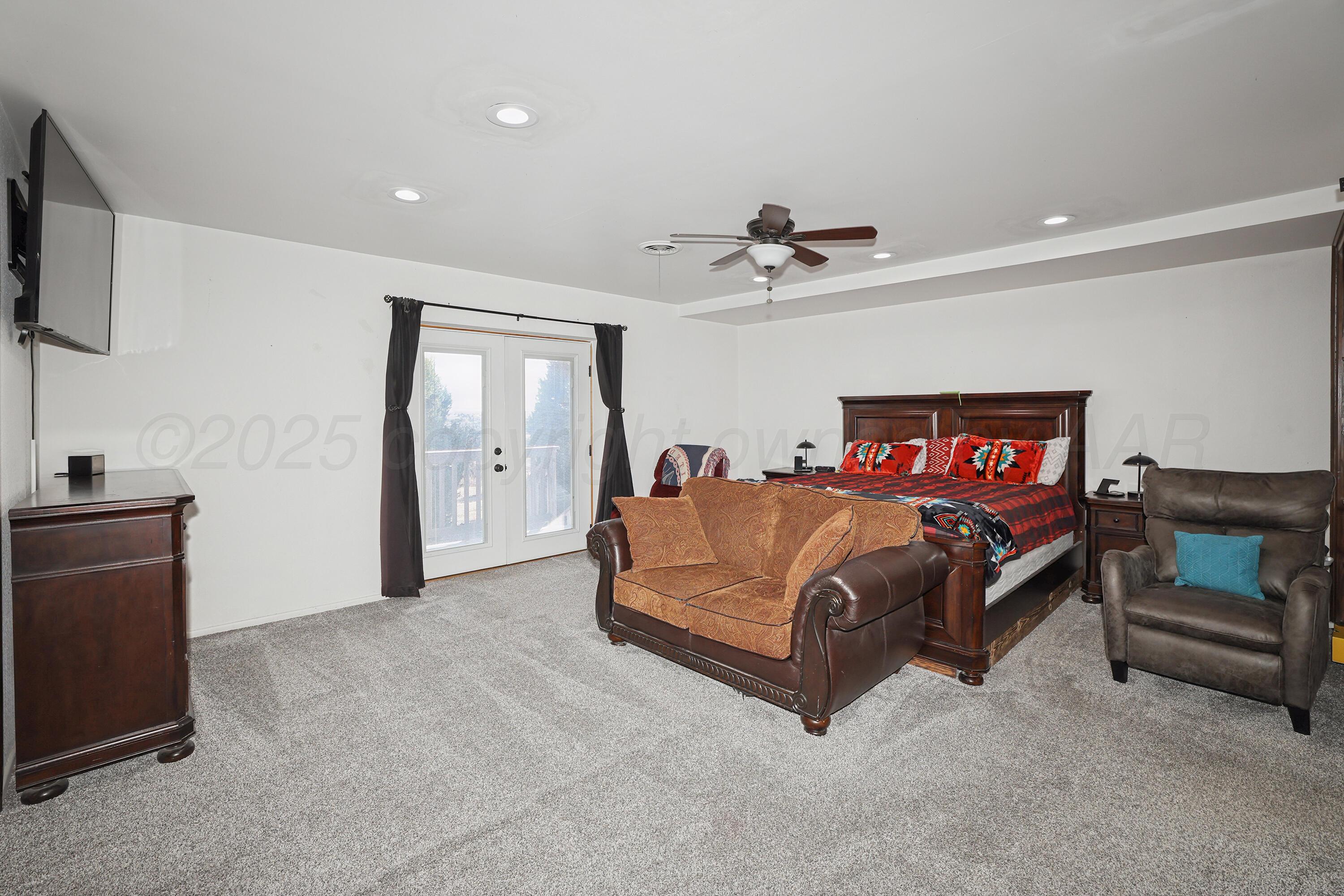 13901 Tangle Aire Point Amarillo, TX 79118 - Photo 13 of 55 a spacious bedroom with a bed and a flat screen tv