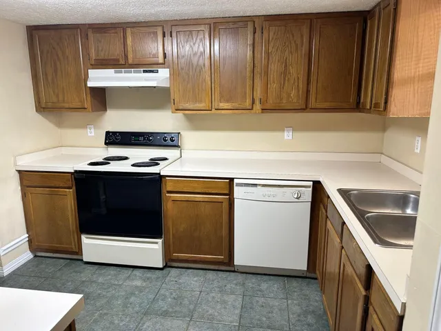 a kitchen with a stove top oven and cabinets