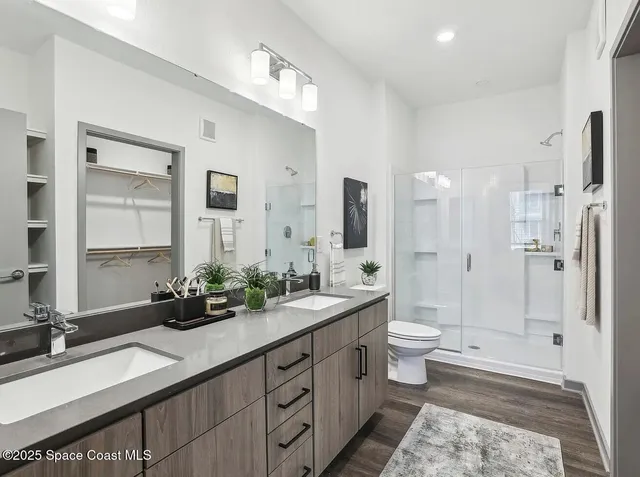 a spacious bathroom with a double vanity sink toilet mirror and bathtub