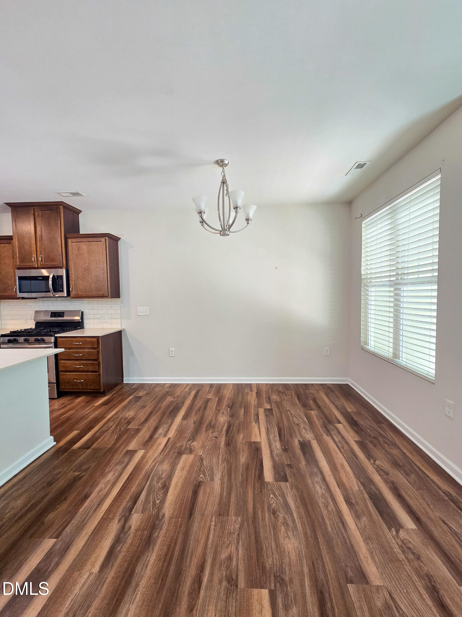6145 Beale Loop Raleigh, NC 27616 - Photo 12 of 36 a view of kitchen and empty room with wooden floor