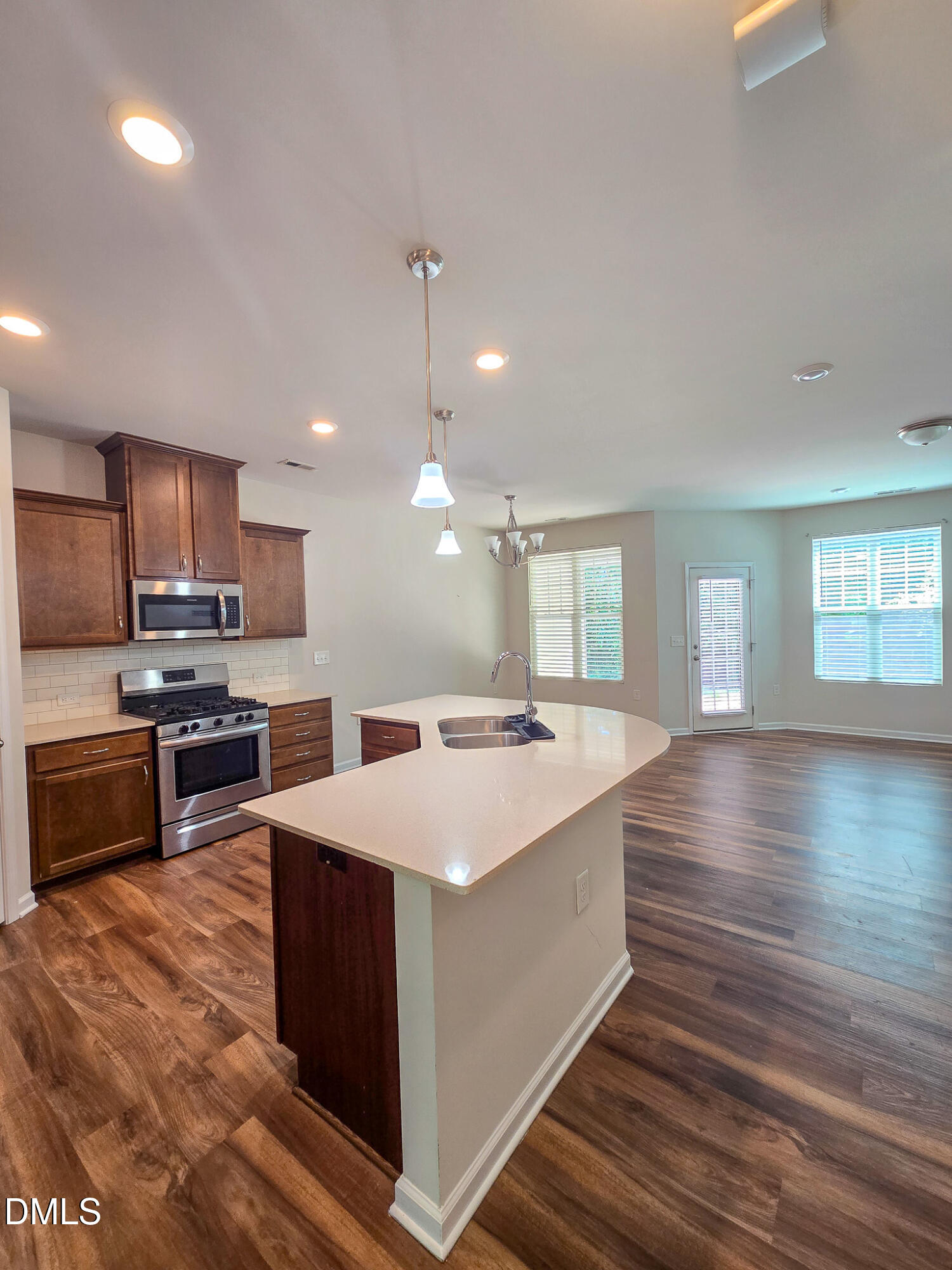 6145 Beale Loop Raleigh, NC 27616 - Photo 7 of 36 a large kitchen with kitchen island a sink dishwasher a stove and a refrigerator with wooden floor