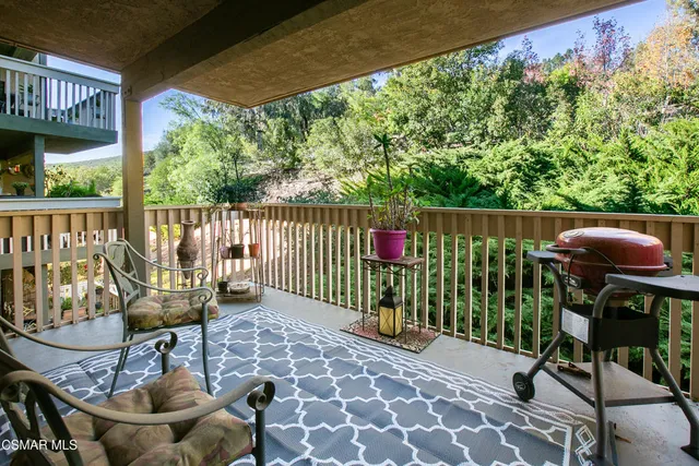 a view of a chairs and table in patio with wooden fence