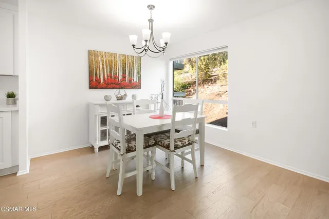 a view of a dining room with furniture a chandelier and wooden floor