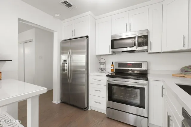 a kitchen with stainless steel appliances white cabinets white stainless steel appliances and a refrigerator