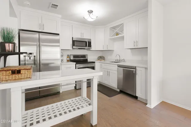 a kitchen with white cabinets and appliances
