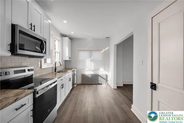 a kitchen with a sink a counter top space stainless steel appliances and cabinets
