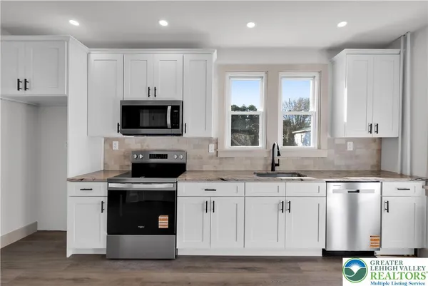 a kitchen with white cabinets stainless steel appliances and sink