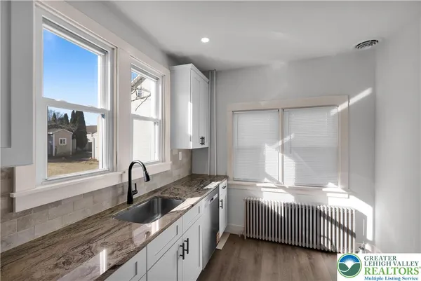 a kitchen with granite countertop a sink and a window