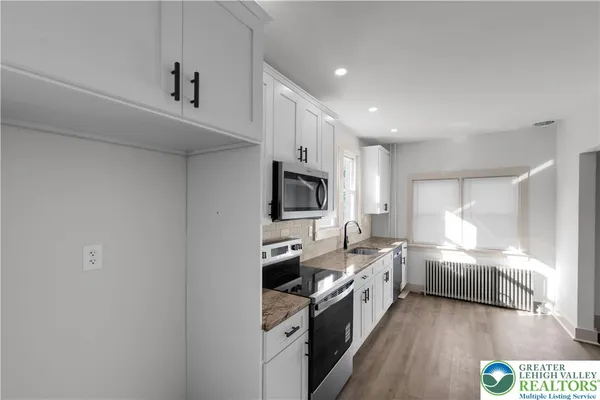 a kitchen with a sink stainless steel appliances and cabinets