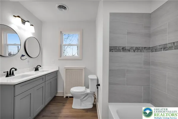a bathroom with a double vanity sink toilet and shower