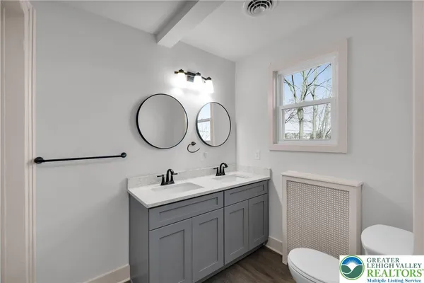 a bathroom with a toilet sink and mirror