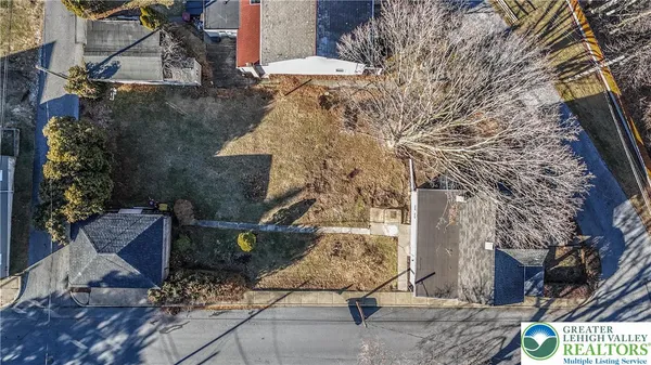 an aerial view of a house with a yard and wooden deck
