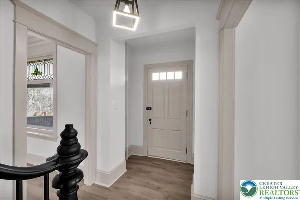 a view of a hallway to a livingroom with furniture