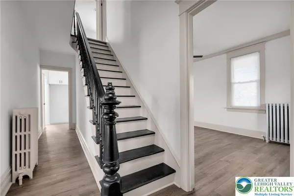 a view of a hallway with wooden floor and windows