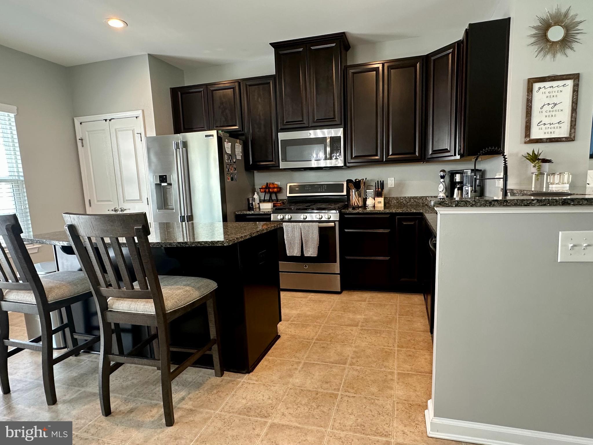 1043 Regency Place Sewell, NJ 08080 - Photo 7 of 24 a kitchen with stainless steel appliances granite countertop a refrigerator a stove a sink dishwasher and a microwave