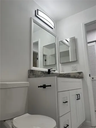 a bathroom with a toilet a sink and mirror
