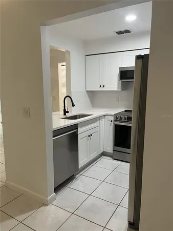 a kitchen with a stove sink and cabinets