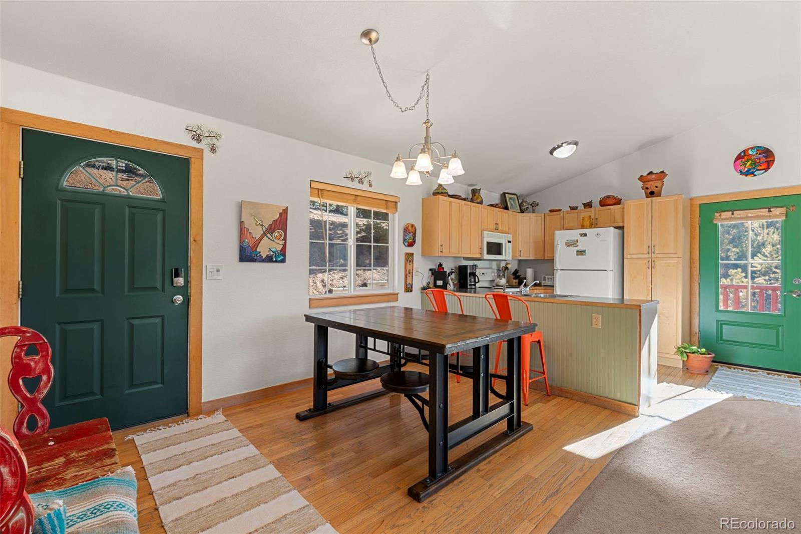 114 Hall Road Bailey, CO 80421 - Photo 5 of 21 a room with kitchen island a dining table and chairs with wooden floor