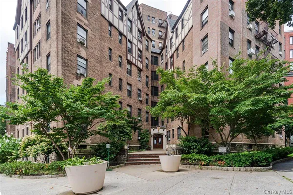 a view of a building with potted plants and big trees