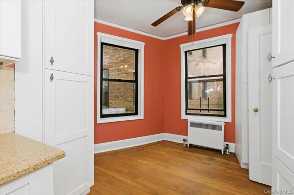 a view of an empty room with window and wooden floor