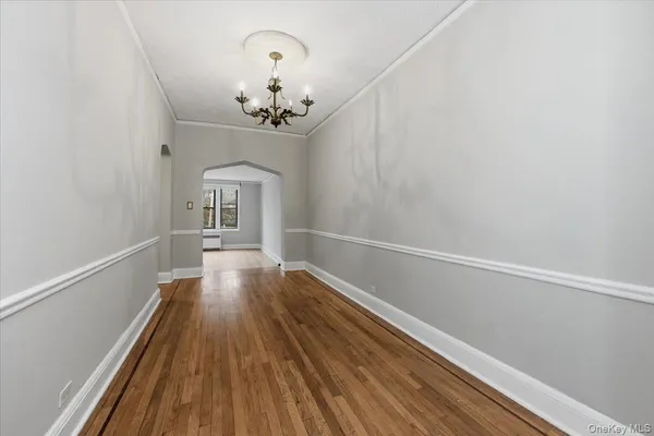 a view of a room with wooden floor and chandelier