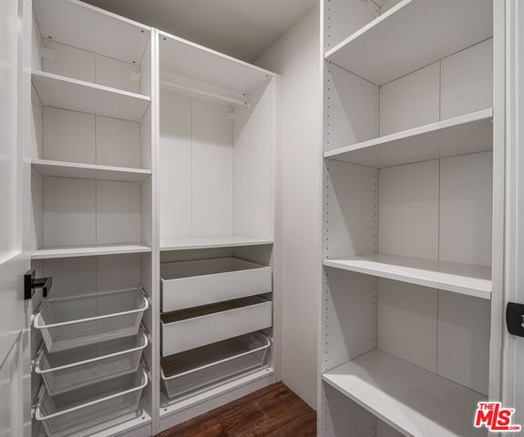 a view of walk in closet with empty racks