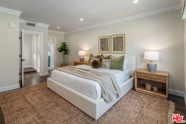 a spacious bedroom with a bed and a lamp