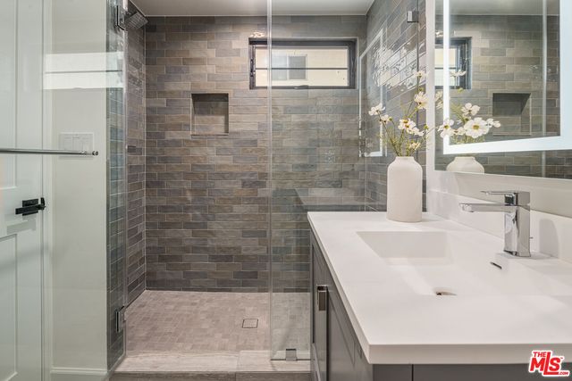 a bathroom with a sink a shower and a mirror