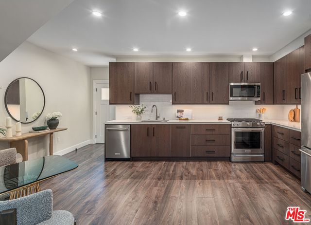 a kitchen with kitchen island wooden cabinets a stove a sink and a center island