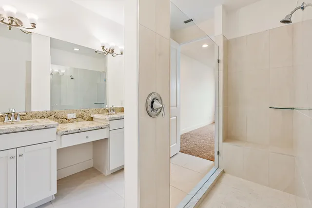 a bathroom with a granite countertop sink a mirror and a bathtub