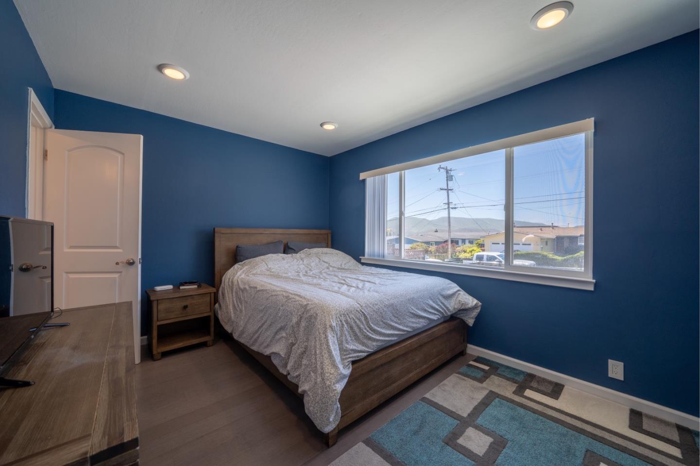 1059 View Way Pacifica, CA 94044 - Photo 13 of 20 a bedroom with a bed and a large window