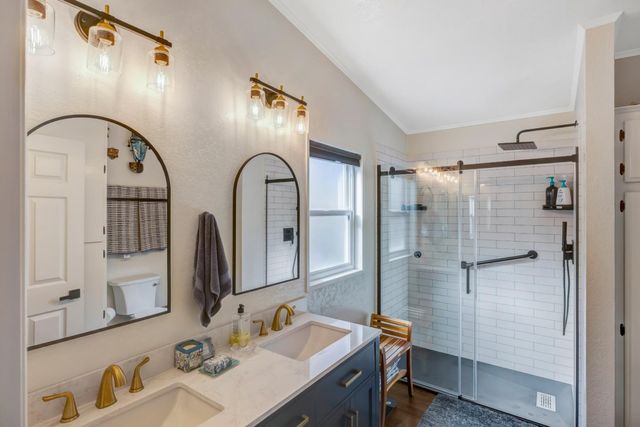 a bathroom with a double vanity sink mirror and shower