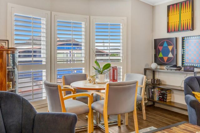a view of a dining room with furniture a rug and a window